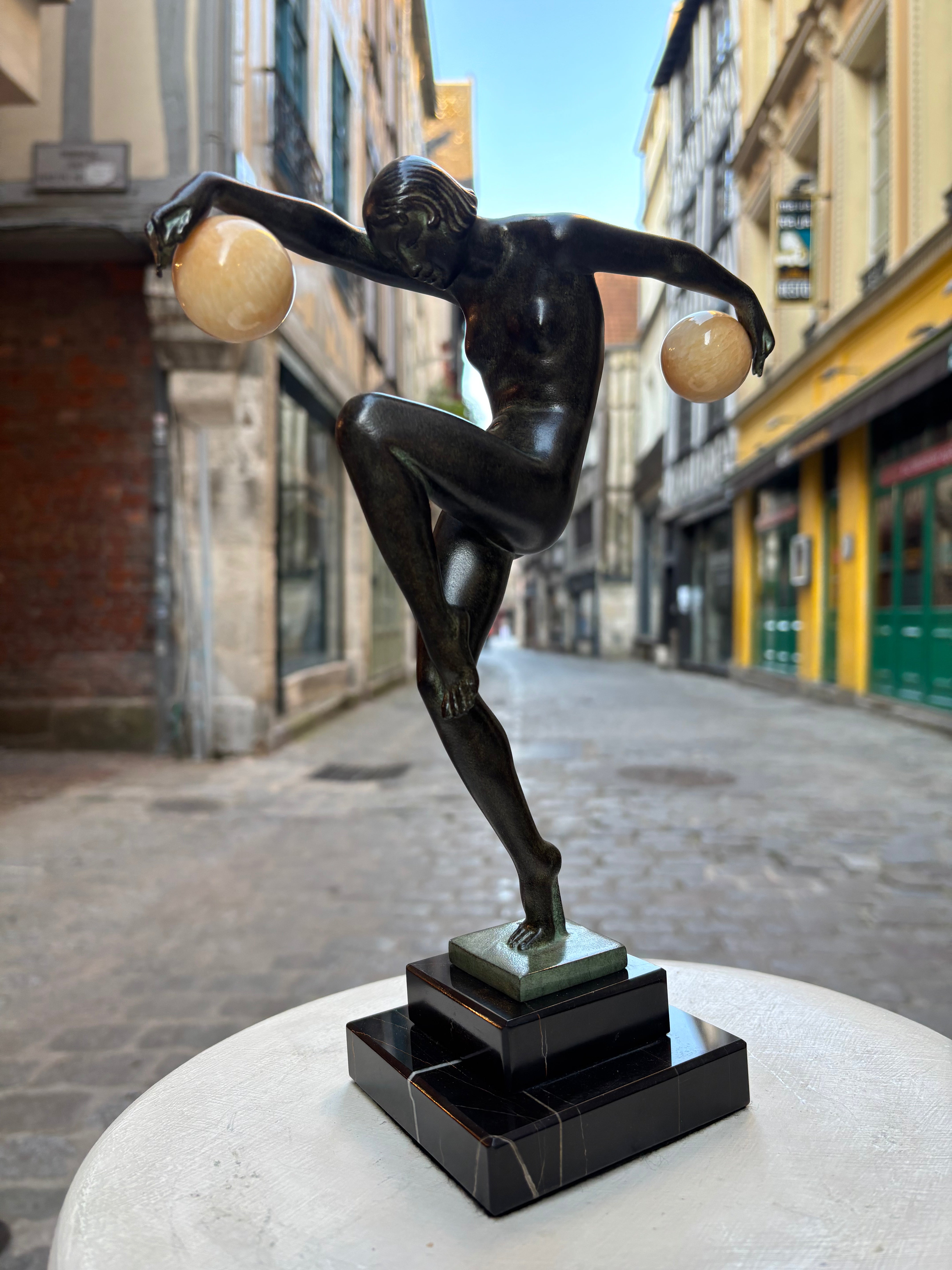Sculpture "Danseuse aux boules" signée DENIS, de style Art Déco avec le cachet de fondeur Le Verrier.
Élégante danseuse en équilibre sur un pied, tenant des boules dans ses mains tendues, conçue vers 1930 et réalisée en métal d'art patiné sur socle en marbre.
H.28 cm
L.20 cm
Fonte contemporaine posthume de la fonderie Le Verrier, avec certificat d'authenticité.
Cette œuvre emblématique de l'Art Déco incarne la grâce et le mouvement caractéristiques des années folles.